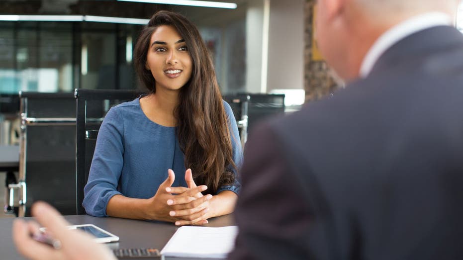 Woman speaks to man at interview desk