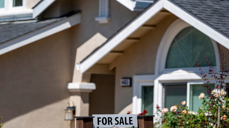 home with 'for sale' sign in front